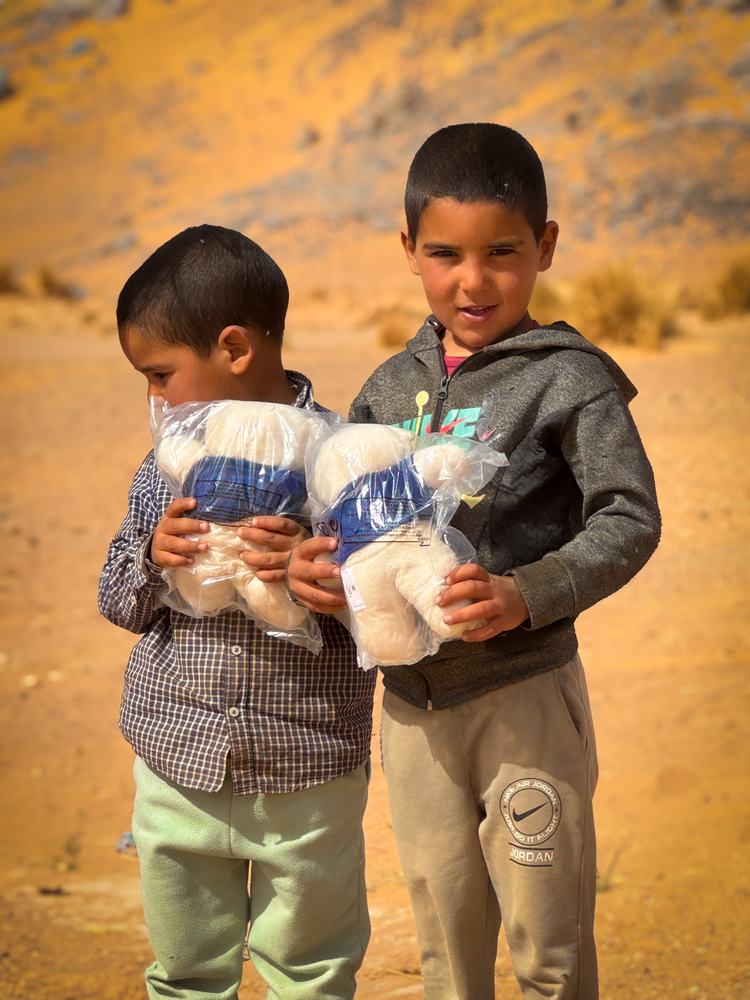 Deux enfants serrant des peluches dans leurs bras